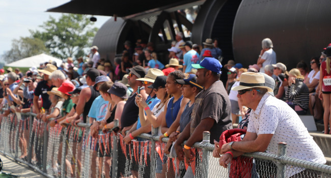 Image of lots of people standing watching Athletics