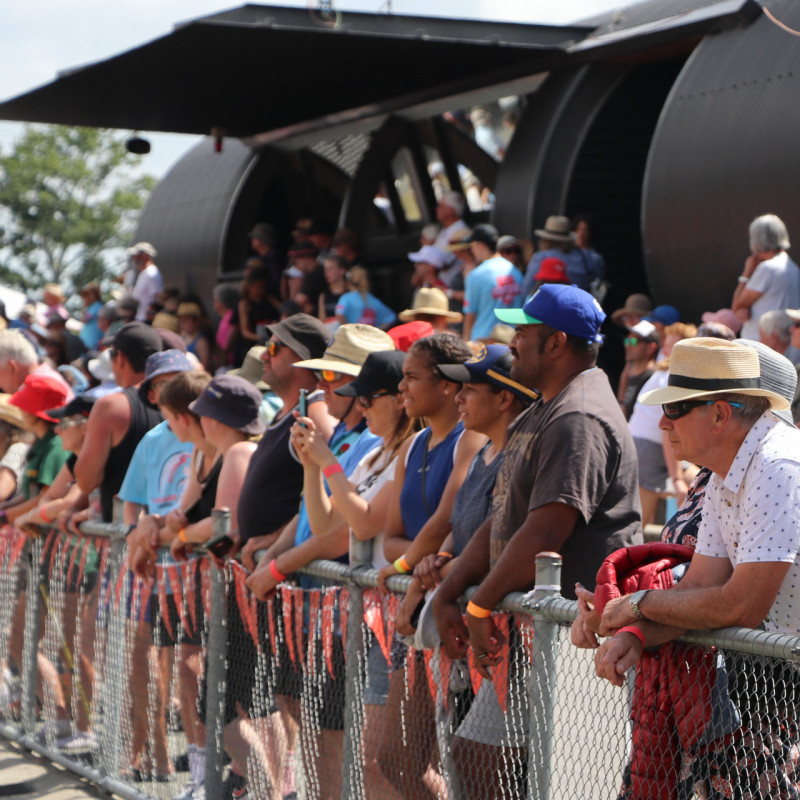 Image of lots of people standing watching Athletics